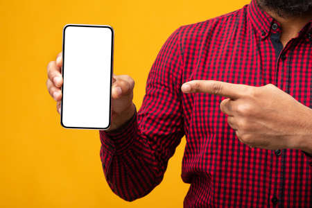 Closeup of unrecognizable african american man holding smartphone with white blank screen in hand...