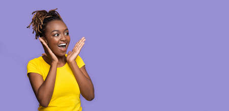 Amazing deal. Surprised black girl looking at copy space on purple studio background, panorama