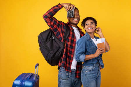 Travel. Cheerful African Tourists Couple With Photo Camera And Luggage Standing Ready For Vacation...