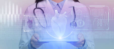 Surgeon with stethoscope examine technological digital hologram. Tablet represent glowing heart of patient, cropped, panorama, double exposureの写真素材