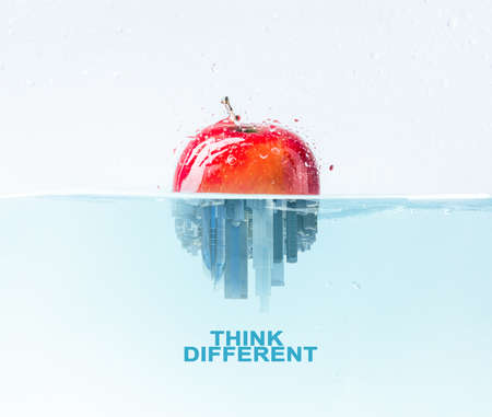 Unique business ideas concept. Half apple half city skyscraper under water, think different lettering, illustrationの写真素材