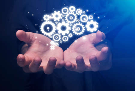 Businessmans Hands Holding Holographic Gears Mechanism Working Together Over Blue Background....
