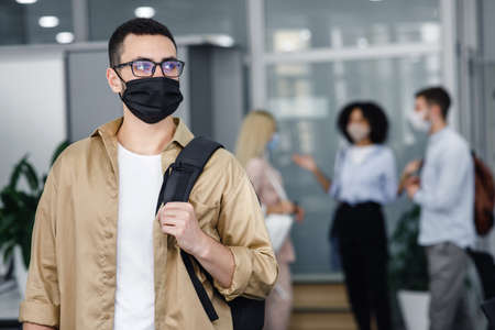 Pandemic and office work with people concept. Focus on millennial man in protective mask and glasses...
