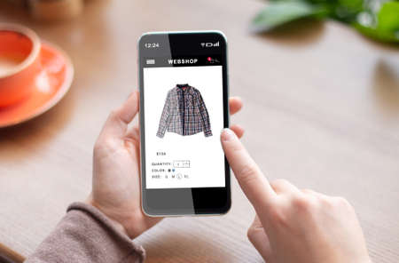 Mobile Shopping Application. Female Hands Holding Phone Buying Clothes Online In Internet Shop App...