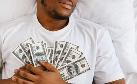Unrecognizable Rich African American Man Sleeping Holding Money Dollars Cash Dreaming About...