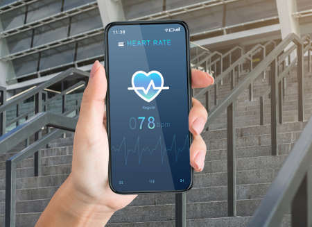 Workout outdoors with device and body care at summer. Female hand holding smartphone with mobile app to check heart activity on screen during exercise on city stairs, pov, close up, collageの写真素材