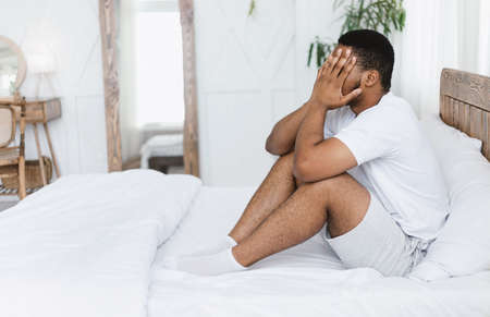 Headache Pain. African American Guy Touching Aching Head Suffering From Ache Sitting In Bed At Home....