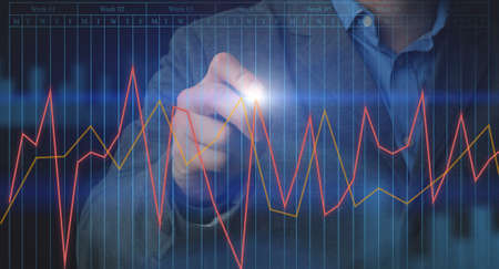 Unrecognizable businessman touching annual financial charts projection on virtual screen, analyzing...