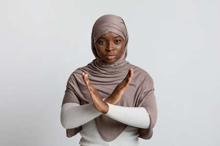 Serious Black Muslim Woman In Hijab Showing Cross Hands Gesture, Demonstrating Denial Sign,...