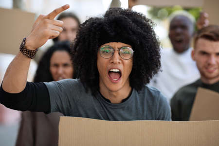 International group of men and women demonstrating protest against pollution, closeup. Angry young...