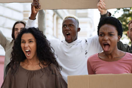 Furious demonstrators making strike against racism, pollution, war. International group of activists...