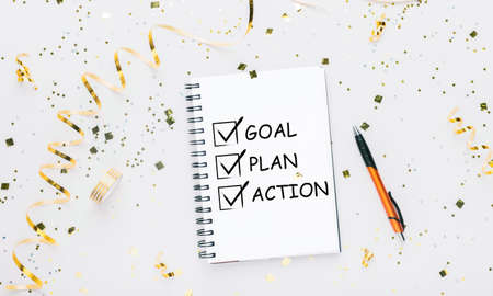 Notebook With 2021 Goals And Words Plan, Action And Goal Over White Background Decorated With Shiny...
