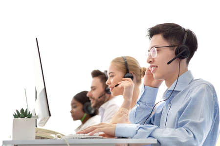 Diverse team of call centre operators working with computers at modern open space office. Group of...