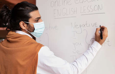 Correspondence Education Online. Indian Teacher In Mask Teaching English Grammar Writing Language...