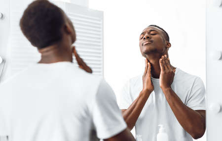 Unshaven Black Man Touching Neck With Bristle And Stubble Before Shaving Face Standing Near Mirror...