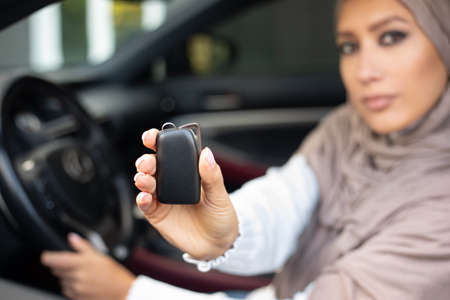 Car Owner. Confident Muslim Woman In Hijab Showing Automobile Keys Sitting In Her New Vehicle,...