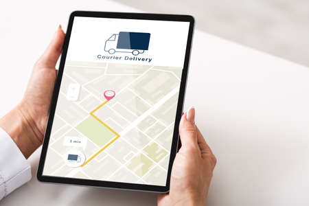 Courier delivery check, gps navigation and online shopping. Woman using tablet with map app on...