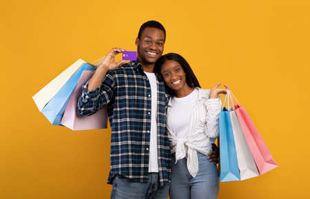 Shopping, free time and seasonal sale together. Cheerful young african american couple in love hold...