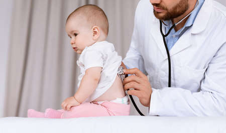 Medical Checkup. Doctor Examining Baby Girl Listening To Her Lungs Using Stethoscope In Hospital. Ill Little Patient Having Pediatrician Appointment In Clinic. Child Healthcare Concept. Croppedの写真素材