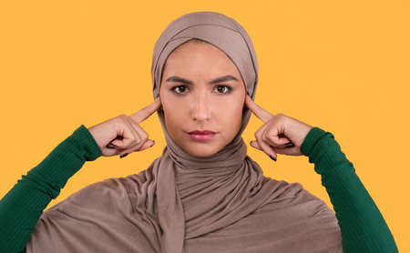 Muslim Lady Covering Ears Not Listening To Rumors And Others People Opinions Standing On Yellow...