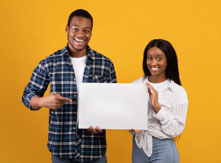 Sale and great offer from couple. Cheerful young african american male and female holding banner...