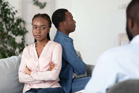 Upset African American Spouses Sitting Back To Back At Marriage Therapy Session At Counselors...