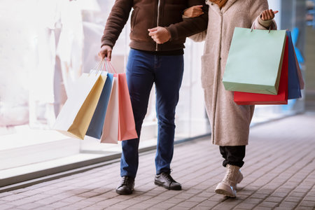 Walking Together After Shopping. Unrecognizable african american man and woman walking down outside near mall in the evening, couple holding bags, closeup of legs. Consumerism Conceptの写真素材