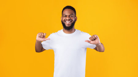 Choose Me. Happy African Man Pointing Fingers Thumbs At Himself Standing Over Yellow Studio...