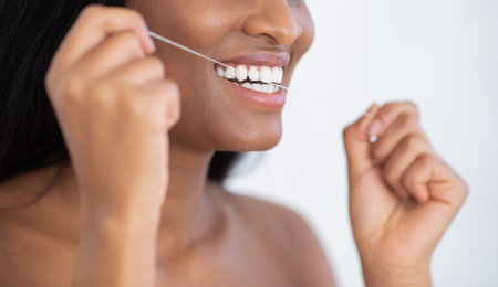 Health care and hygiene of mouth. Beautiful smiling african american female holding dental floss,...