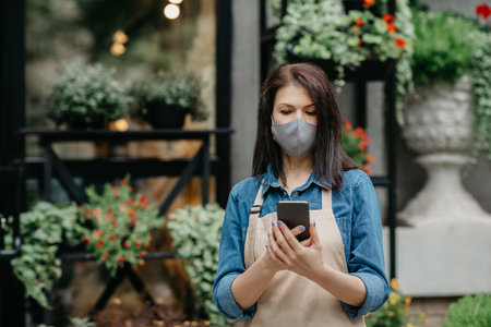 New normal, online ordering and small business during lockdown. Busy millennial owner female in...