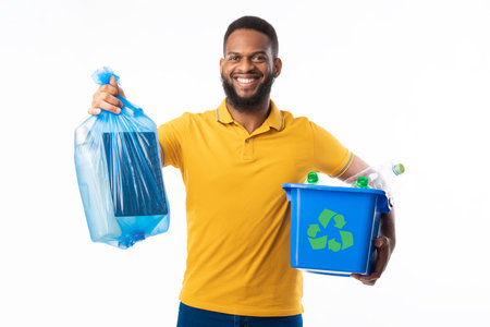 Black Man Holding Box With Recycling Plastic Litter And Blue Garbage Bag Standing On White Studio...