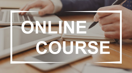 Unrecognizable businessman typing on laptop and writing in notebook in modern office, having online business course, side view. Creative image for online business education, trainingの写真素材