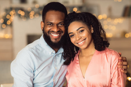Happy Loving Family. Portrait of beautiful young african american couple in love posing and looking at camera. Smiling black bearded man embracing and hugging his pretty woman. Healthy Relationshipの写真素材
