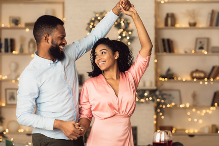 Happy Loving Family. Portrait of beautiful young african american couple in love dancing and looking at each other. Smiling black bearded man having fun with his pretty excited womanの写真素材