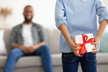 Fathers Birthday. Son Preparing Surprise For Dad Holding Wrapped Gift Box Behind Back Congratulating Daddy On His B-Day At Home. Selective Focus On Present, Cropped. Family Holiday Concept. Rear Viewの写真素材