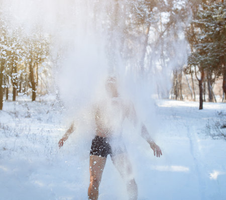 Winter fun and tempering open air procedures. Senior guy in underpants throwing snow on himself, developing resistance to cold at forest. Healthy living and acclimation conceptの写真素材