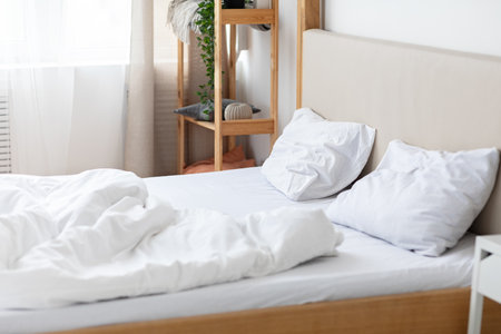 Bedroom interior, candid photos concepts. Empty double bed with two pillows and white blanket, free...