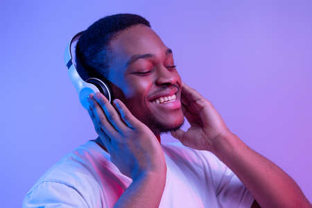 Music Lover. Handsome Black Man Listening Favorite Songs In Wireless Headphones, Enjoying New...