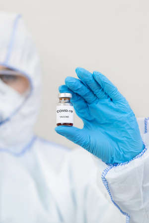 Coronavirus vaccination, health protection and immunization. Medic in hazmat suit, gloves, mask and...