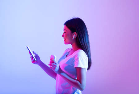 Favorite music for relax and sports during covid-19. Smiling beautiful asian teen lady in wireless...