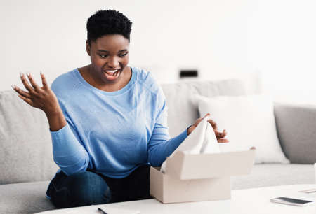 Wrong Package. Portrait of surprised frustrated black woman unpacking box, shocked by bad delivery...