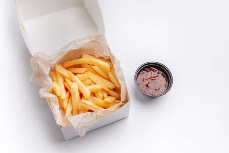 Fast food service, quick delivery and modern menu for home party or lunch at office. Appetizing fresh french fries in paper boxの写真素材