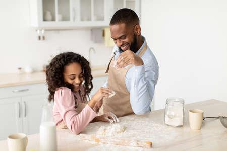 Having Fun While Cooking Concept. Portrait of happy african american dad and his little daughter...