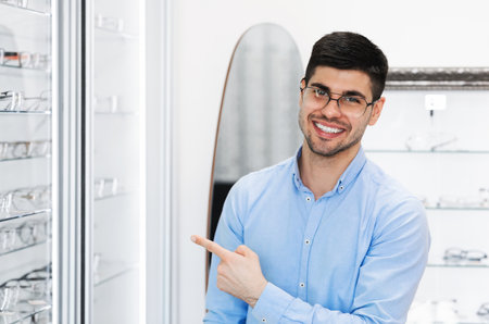 Eyesight And Vision Concept. Portrait of smiling man wearing eyeglasses, standing at optics store...
