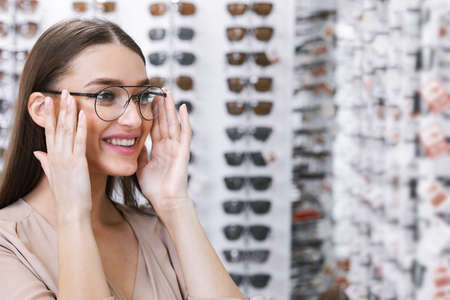 Ophthalmology And Vision Correction Concept. Portrait of smiling young female client wearing new...