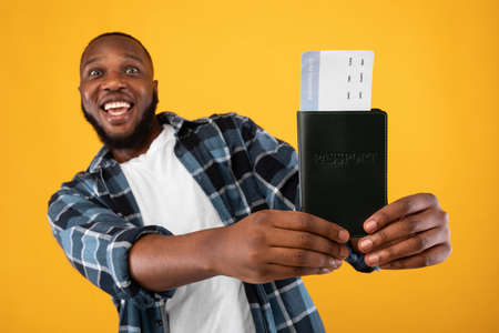 Vacation, Finally. Excited Black Man Showing Travel Tickets And Passport To Camera Posing Standing...