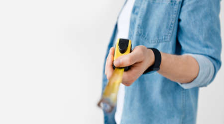 Carpenter, handyman, construction with tape-line and engineer size measuring for repair. Millennial...