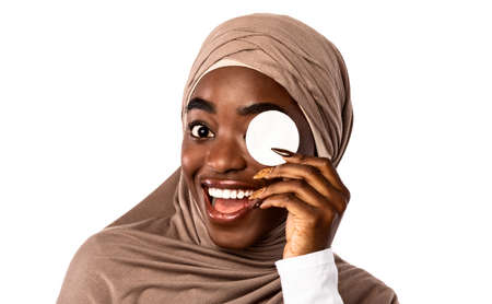 Skincare Routine. Excited Islamic African American Young Woman Holding And Using Cotton Pad,...
