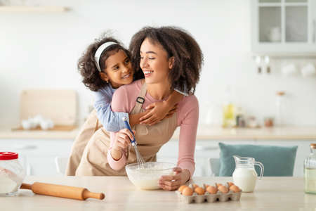 Baking With Mother Is Fun. Happy African American Woman And Her Little Daughter Mixing Flour And...