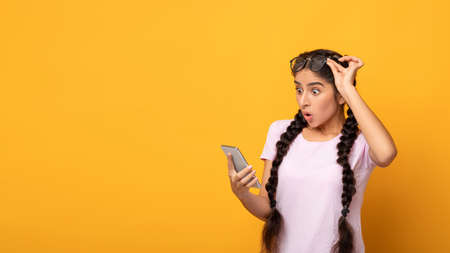 Omg. Portrait Of Emotional Shocked Indian Lady Holding And Using Mobile Phone, Taking Off...
